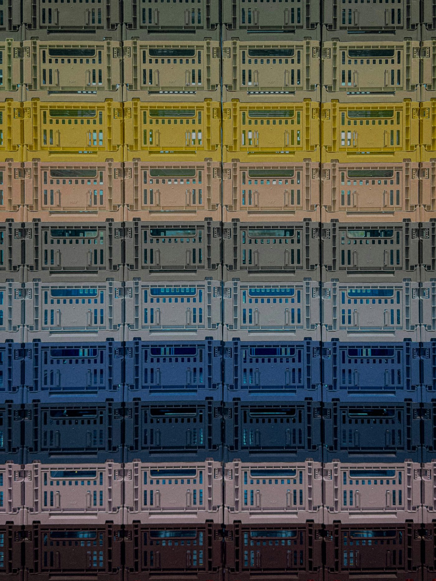 Stacked plastic crates in graded colours made from recycled plastic