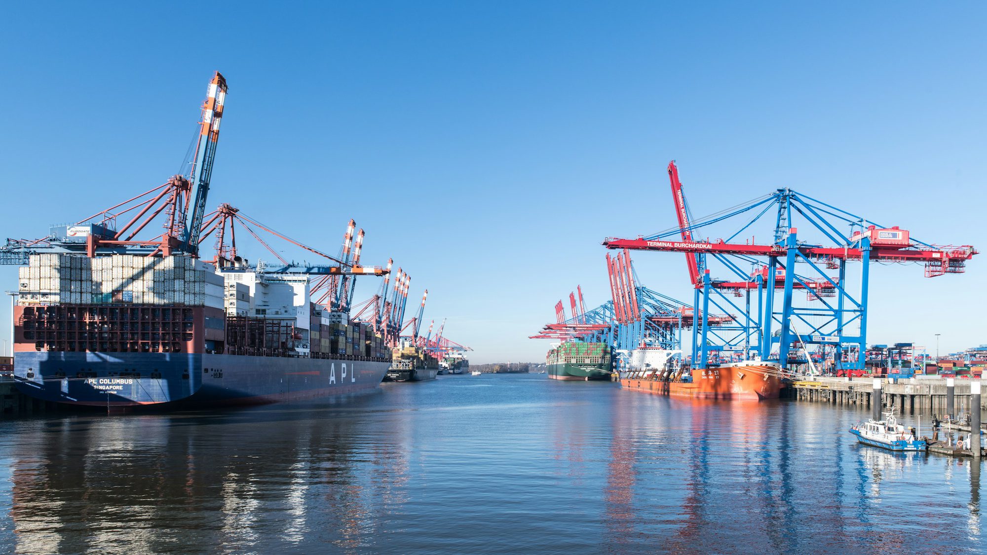 Container ships and gantry cranes at a port terminal handling offshore freight for Australian manufacturers