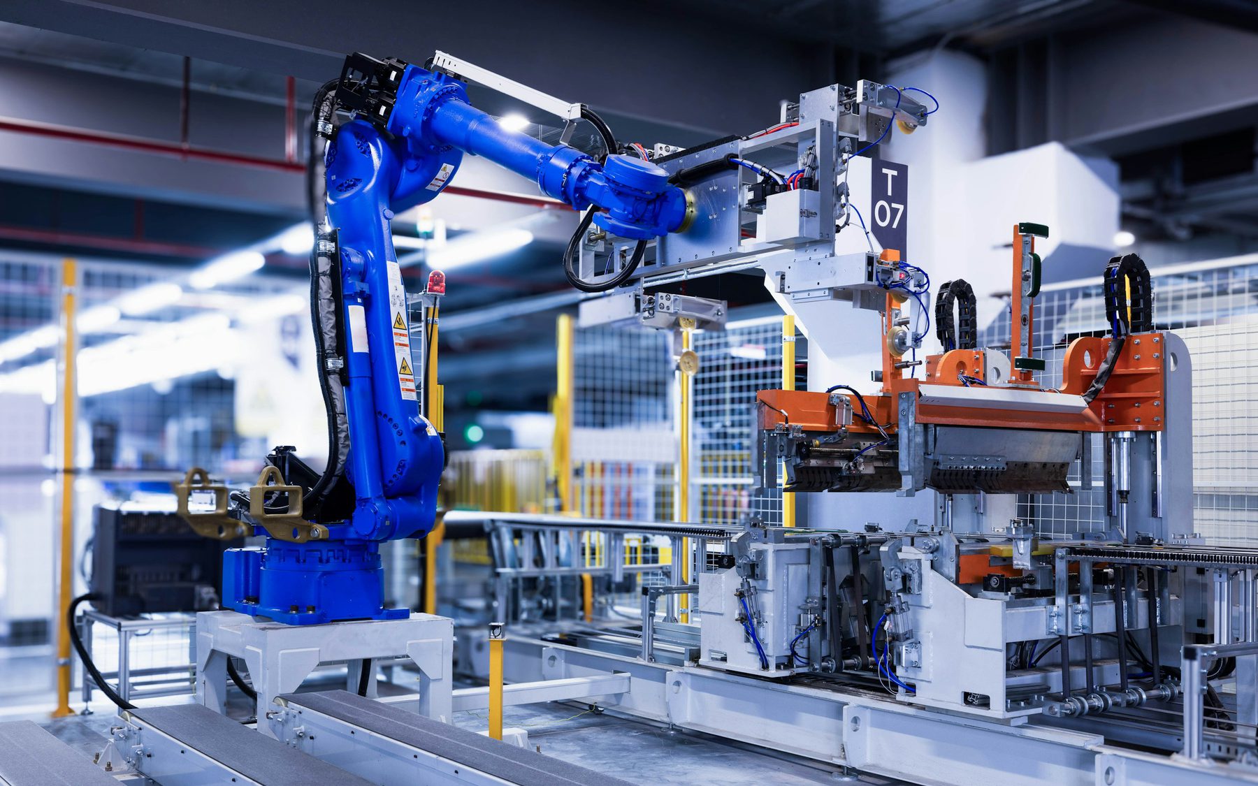 Industrial robot arm working alongside automated machinery in an Australian plastics factory