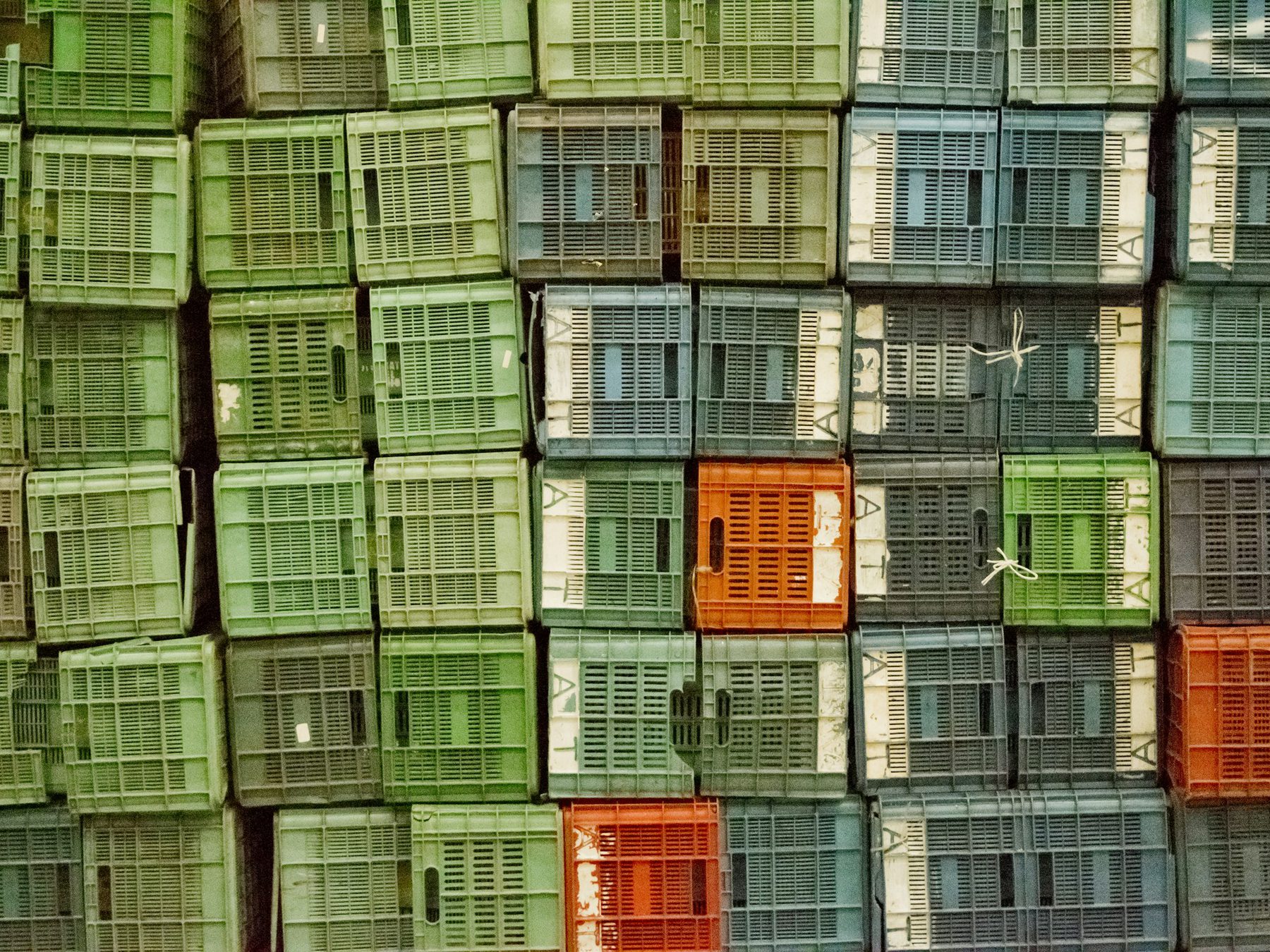 Wall of stacked returnable crates made from recycled plastic products in Australia